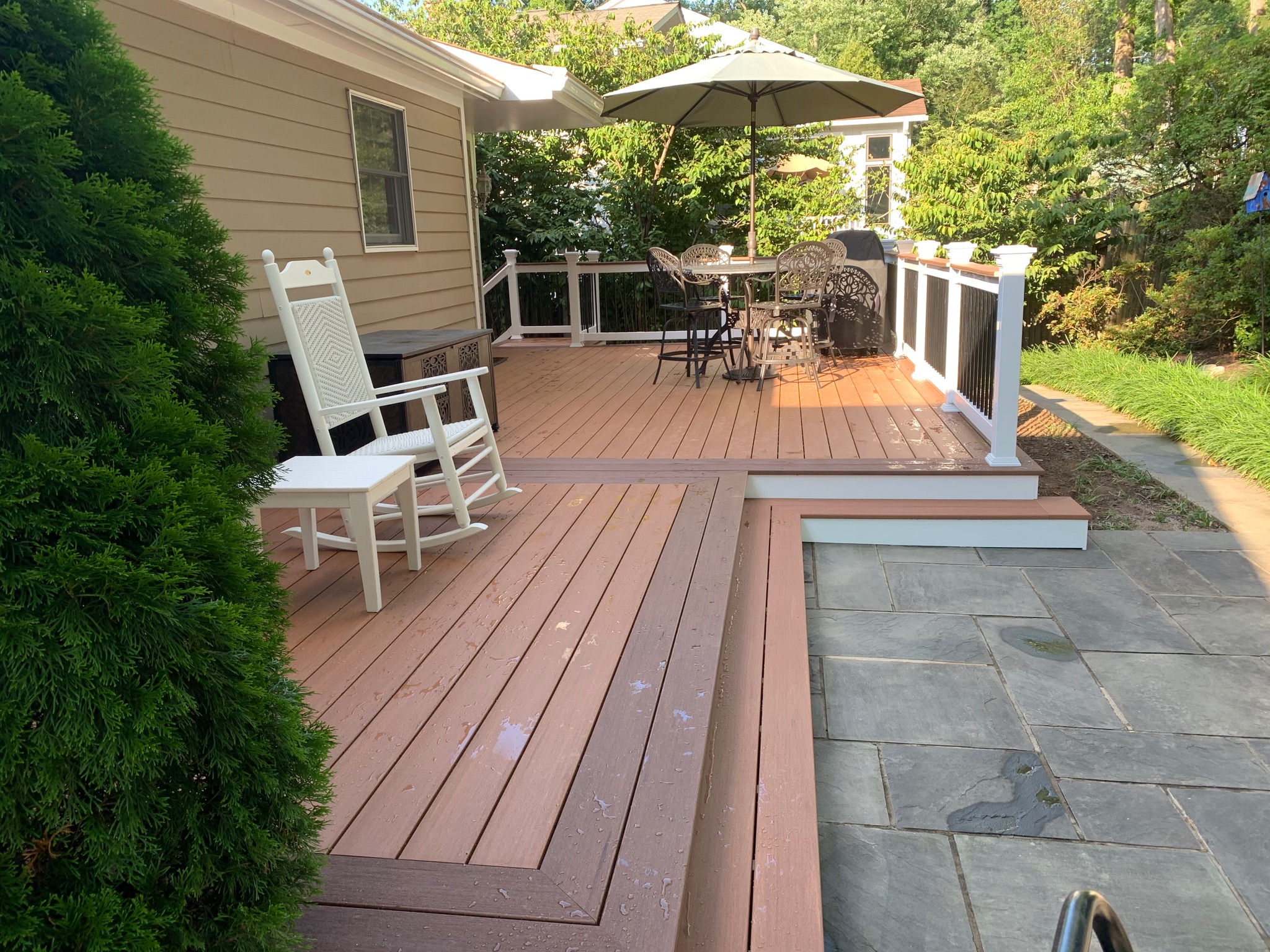 A wooden deck with chairs and an umbrella