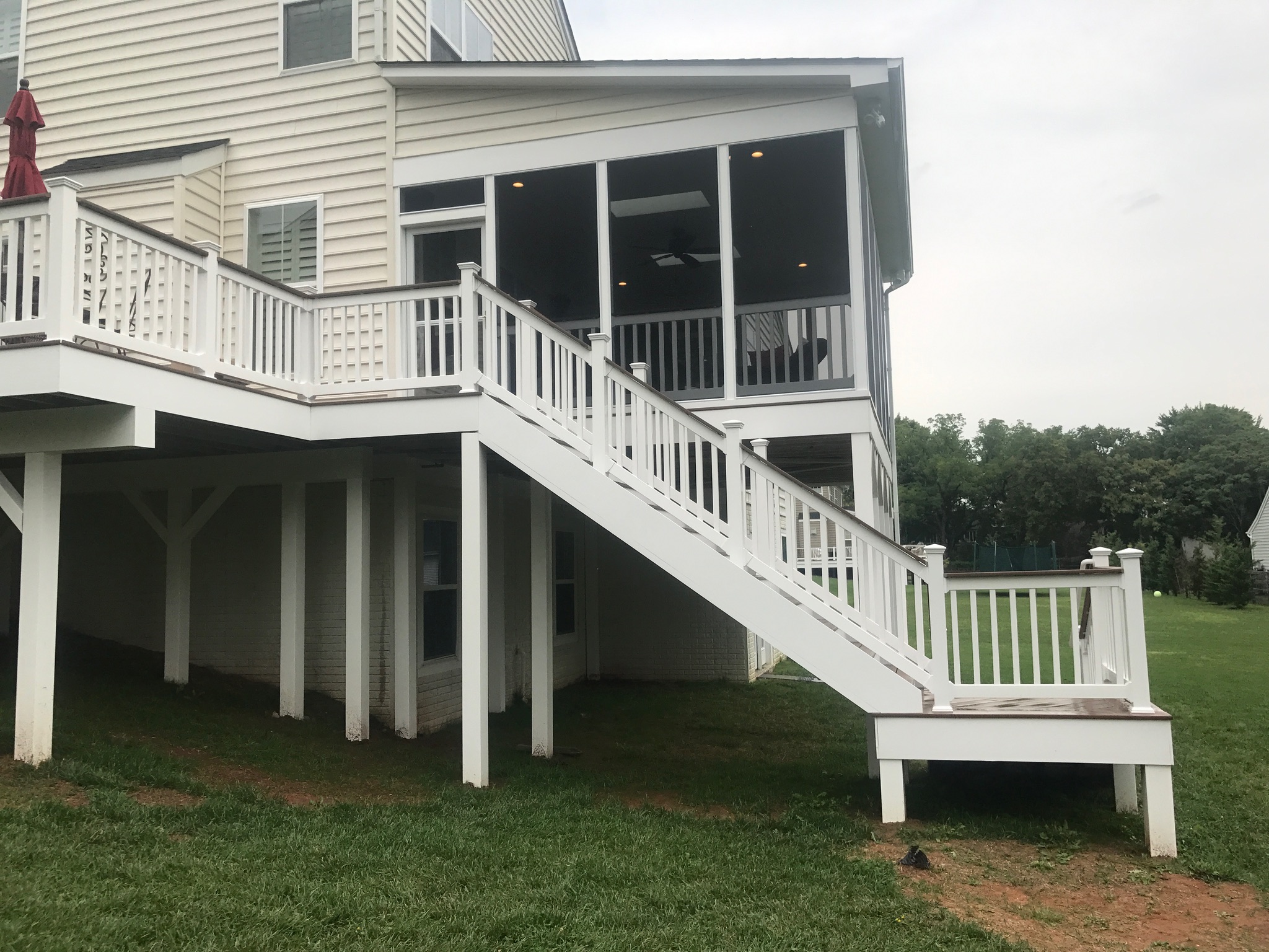 A large white house with a deck and stairs