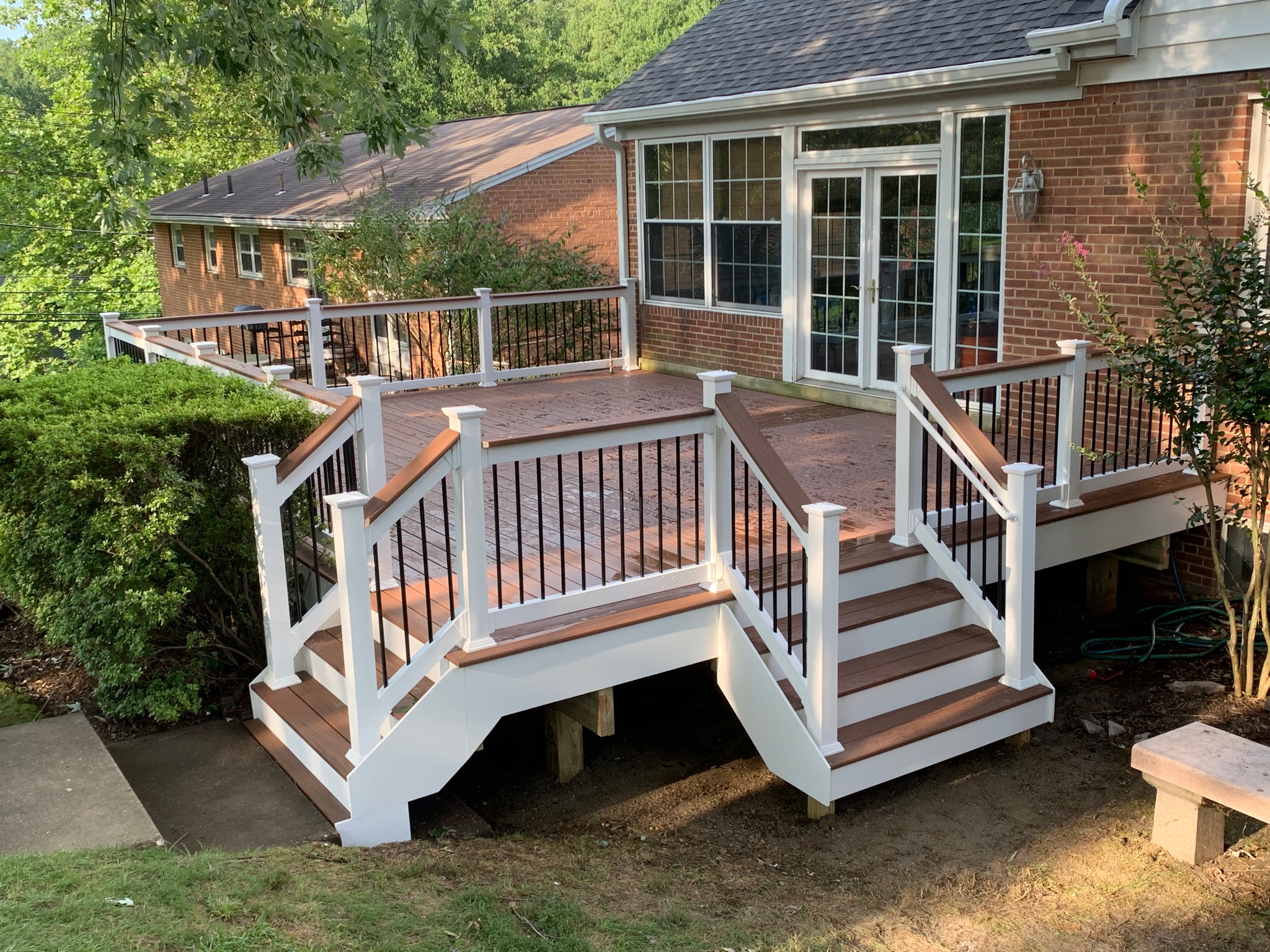 A wooden deck with white railing and steps