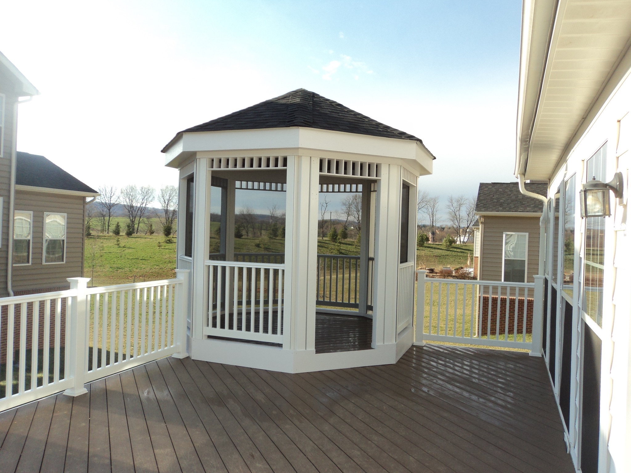 A white gazebo sitting on top of a wooden deck