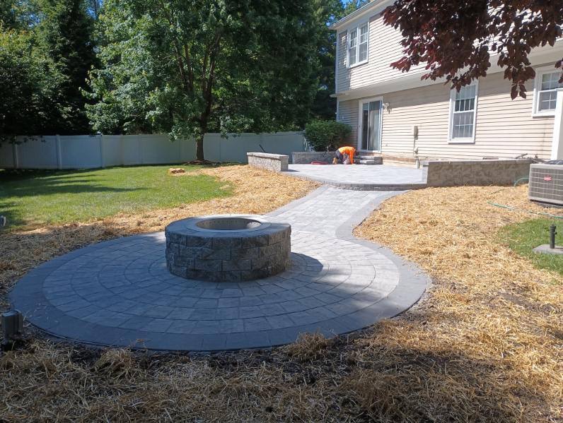 A patio with a fire pit in the middle of it