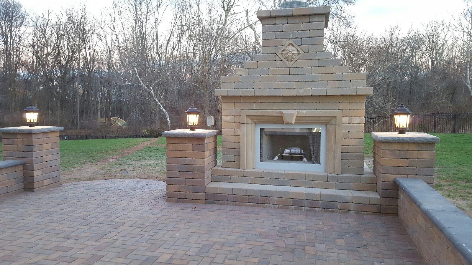 A brick fireplace with two lanterns on top of it