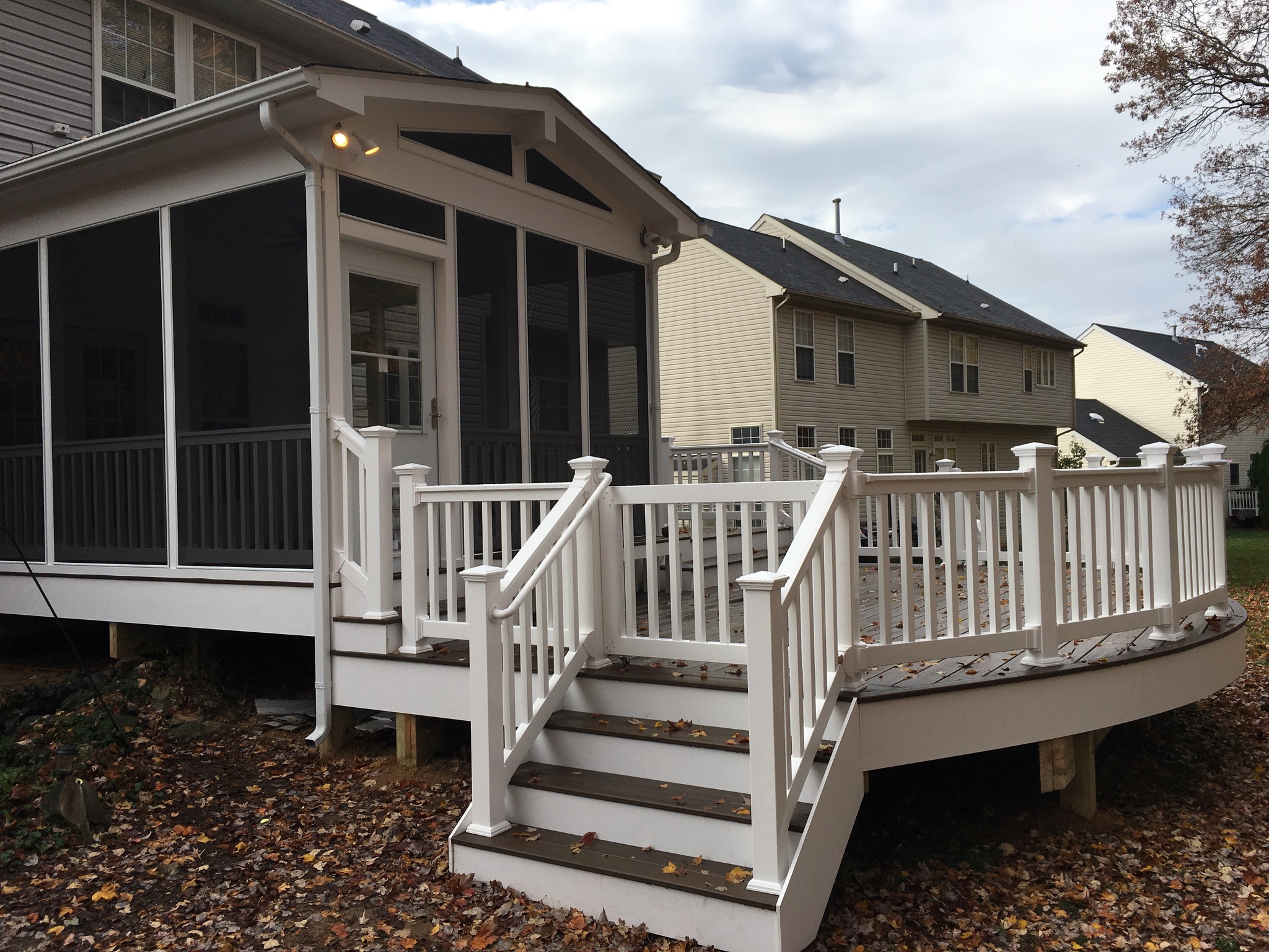 A white porch with a white railing and steps