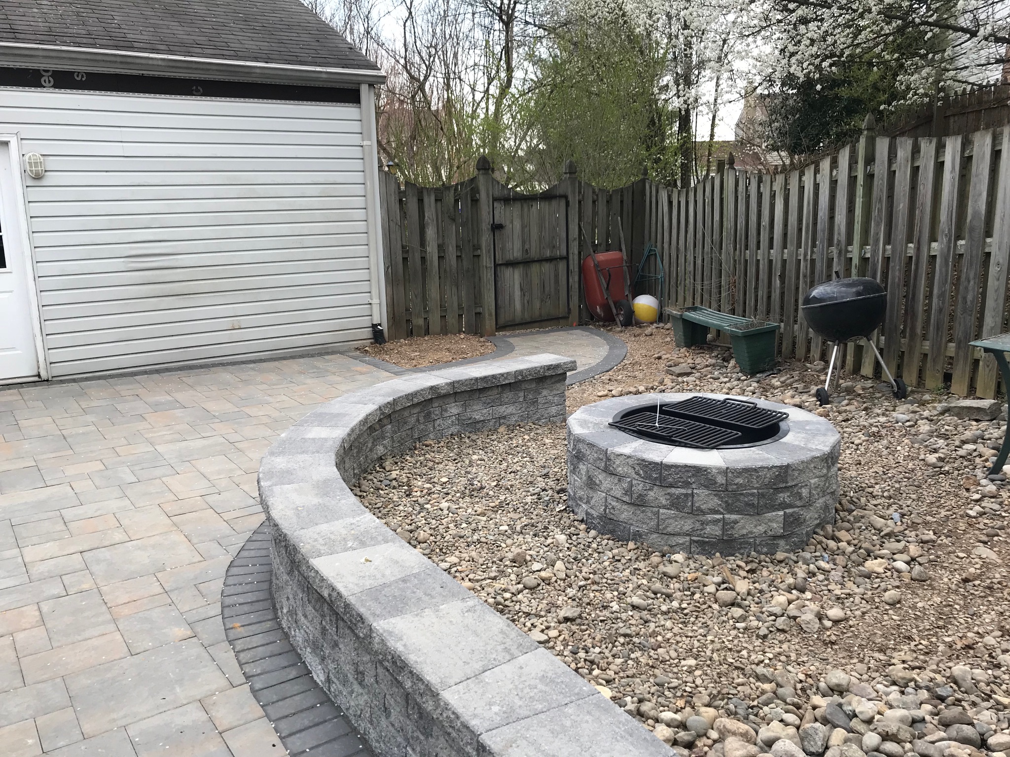 A backyard with a fire pit surrounded by rocks