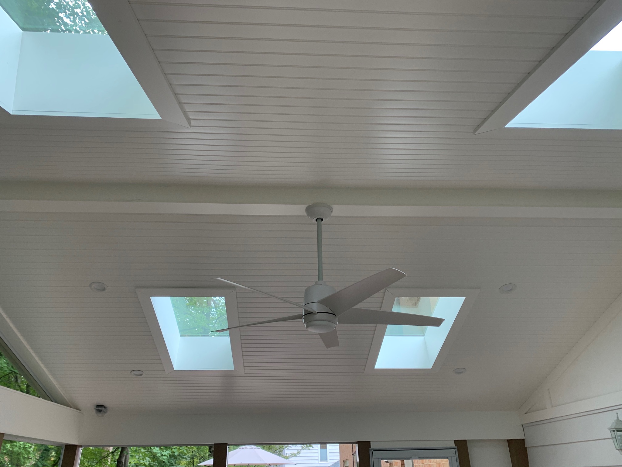 A living room with a ceiling fan and two windows