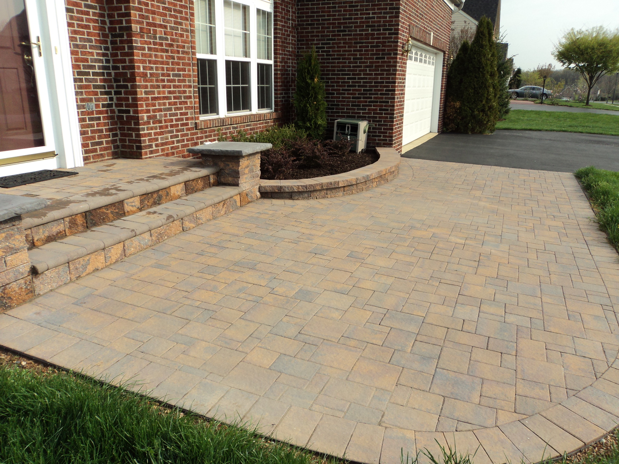 A brick patio with steps leading up to a house