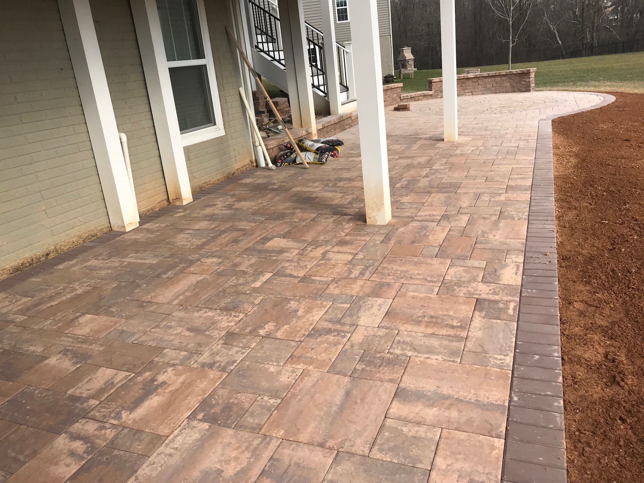 A patio with a brick walkway next to a house