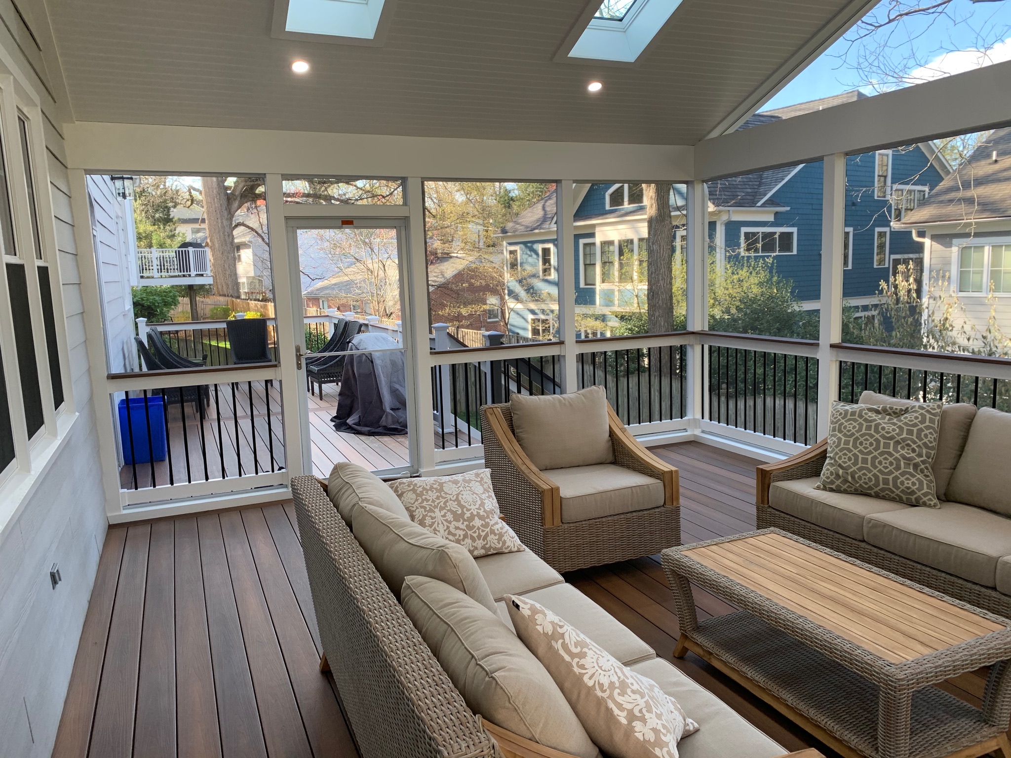 A covered porch with couches and chairs on it