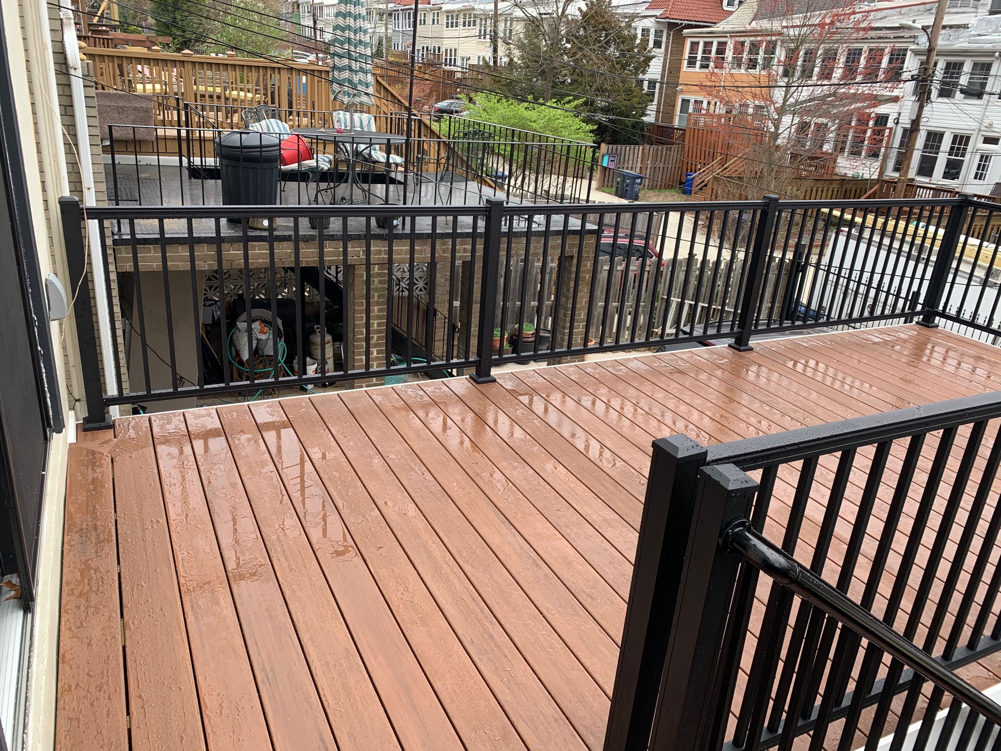 A wooden deck with a black railing and a dog on it