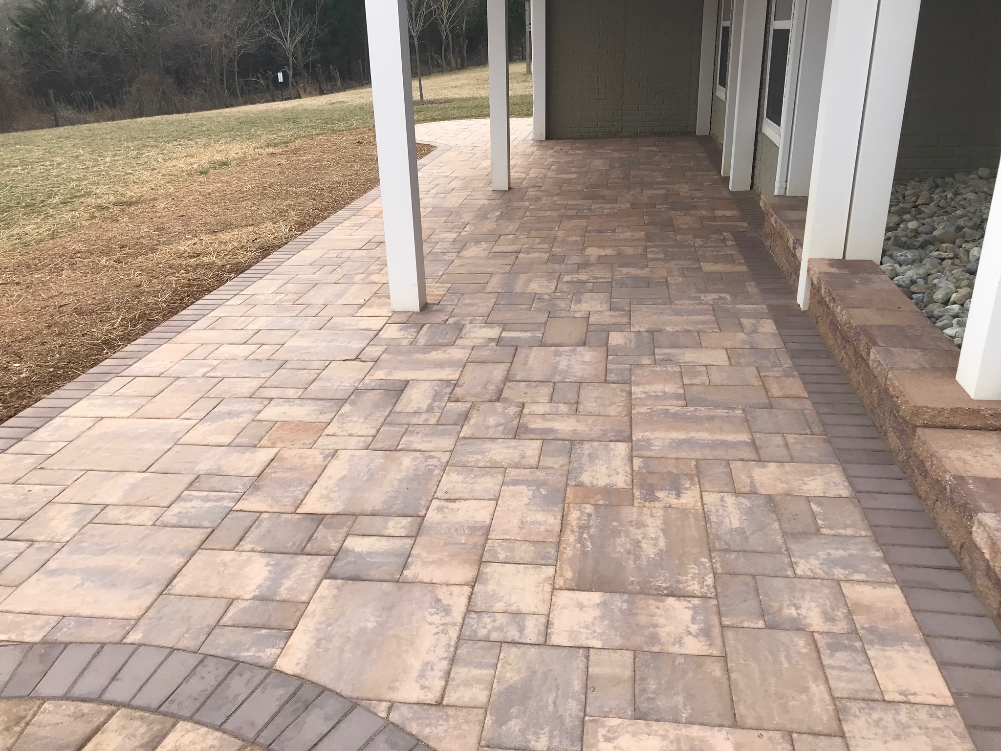 A brick walkway leading to a front door of a house