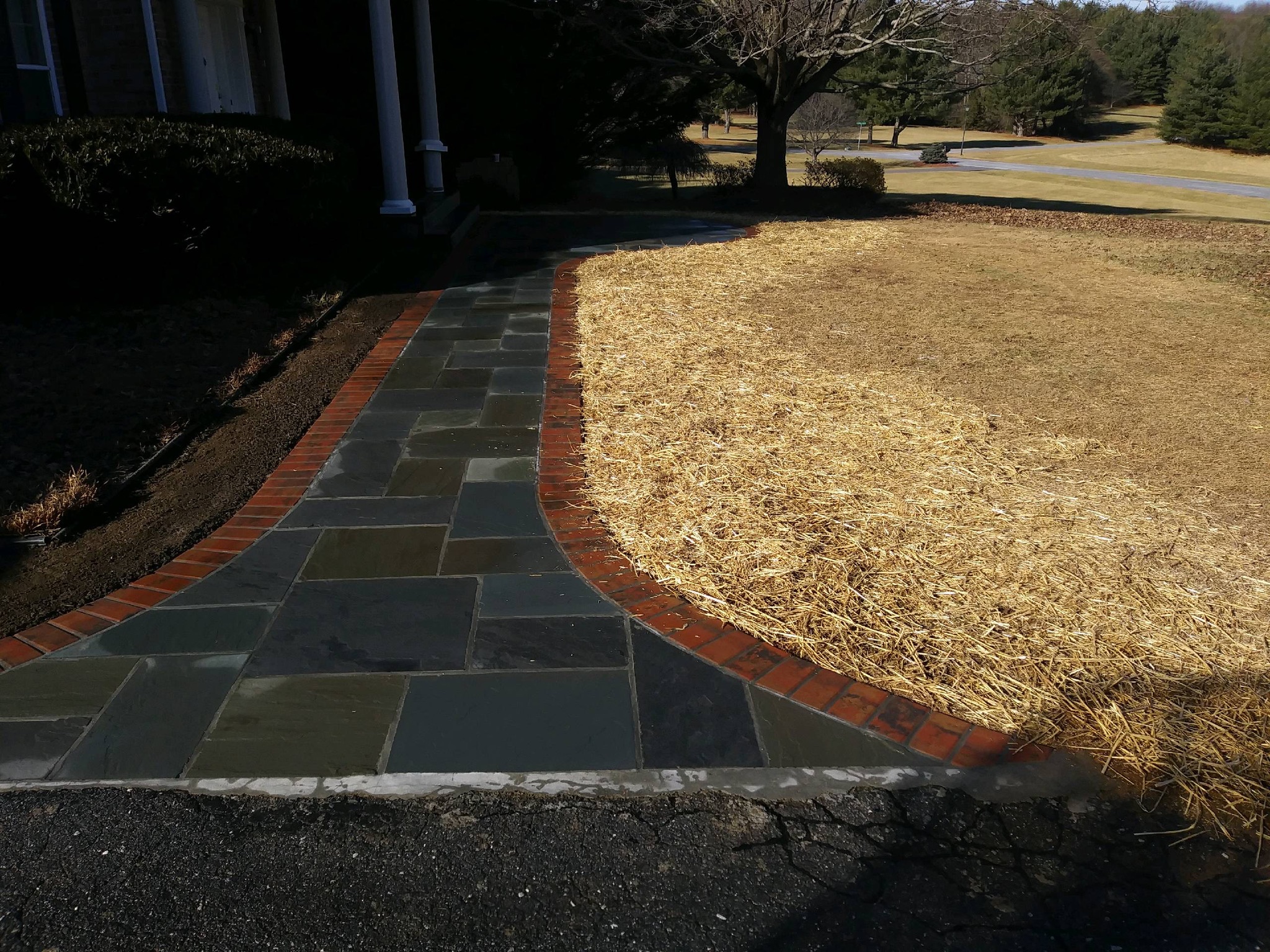 A brick walkway in front of a house