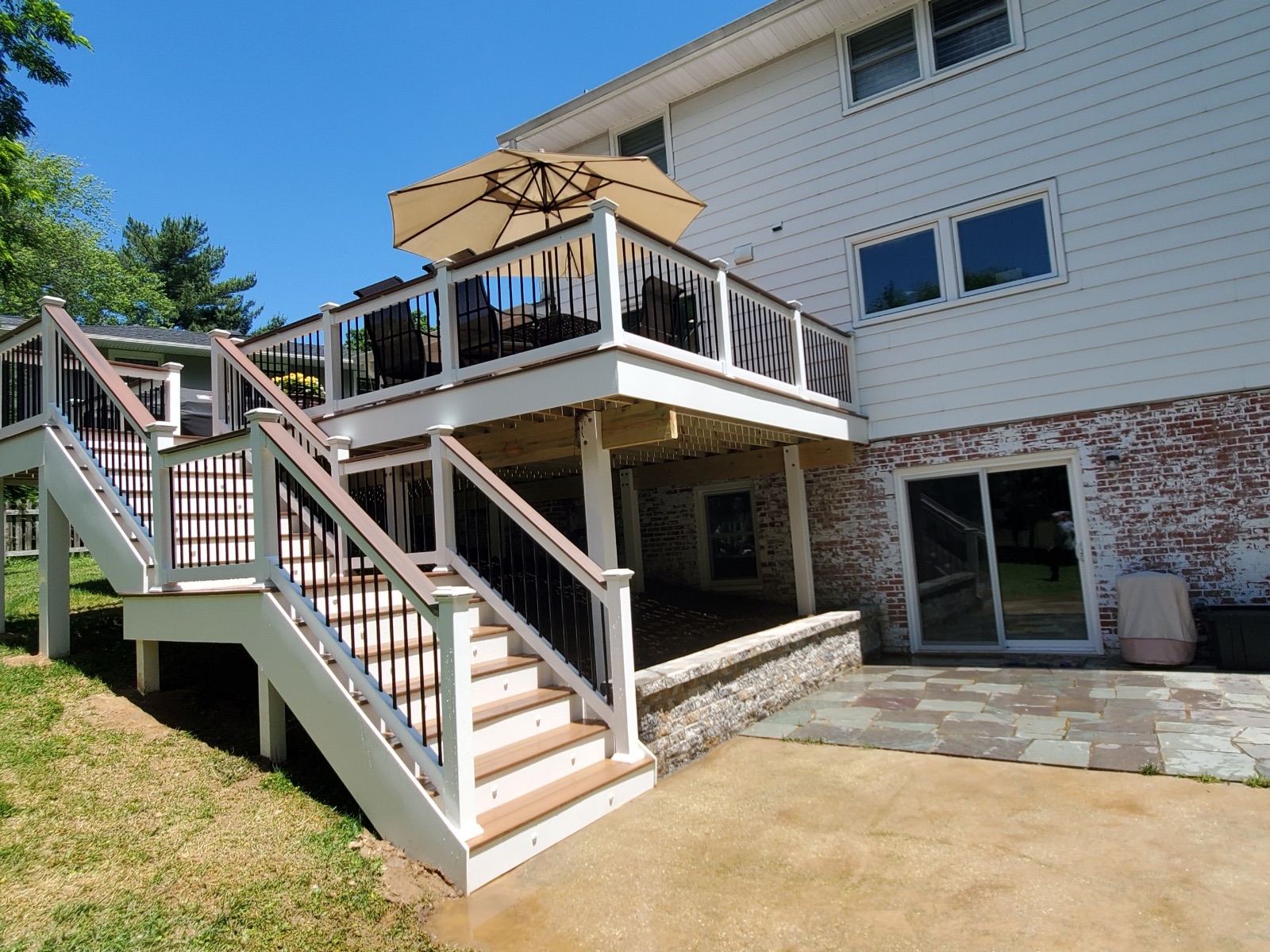 A house with a deck and a patio with an umbrella