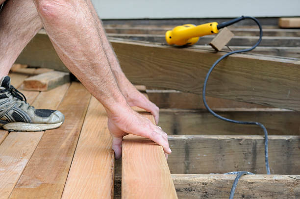 Skilled deck professional checking railing alignment and surface spacing on custom build