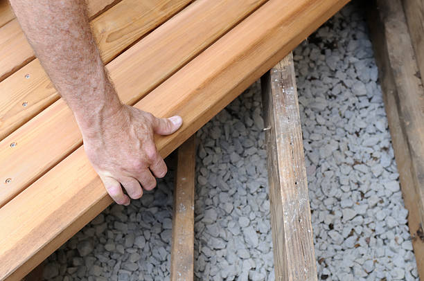 Homeowner enjoying newly built backyard deck behind Gaithersburg house during evening gathering