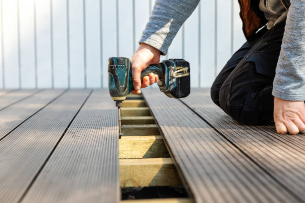 Deck professional inspecting framing connections and surface alignment before finishing outdoor structure